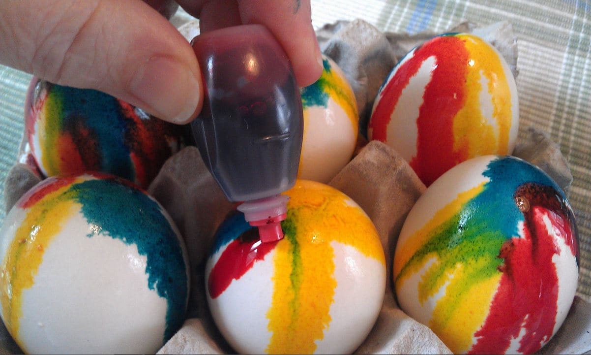 Alternate dripping various colors of food coloring until you have achied the desired results for your tie dye Easter eggs