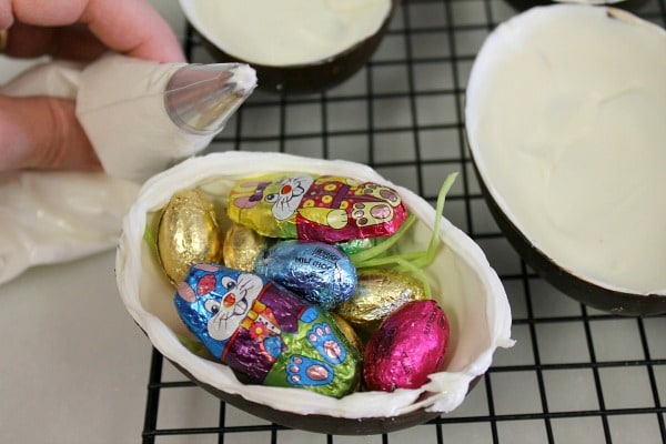 Fill the bottom half of hollow chocolate eggs then pipe icing on edge