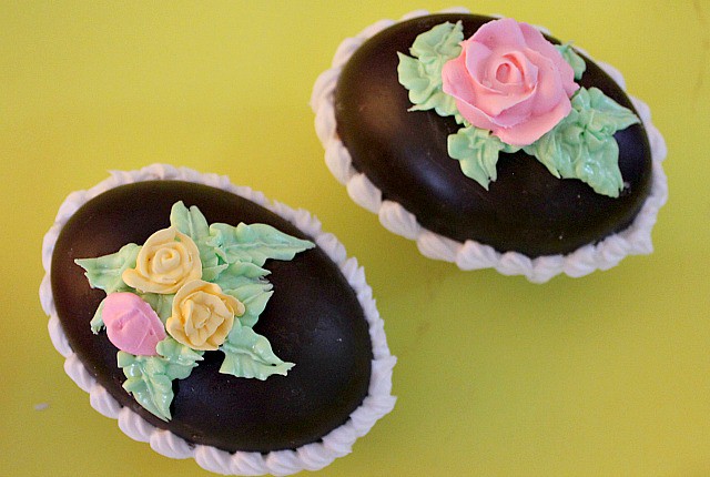 Use royal icing to add roses and leaves to the top of the hollow chocolate eggs