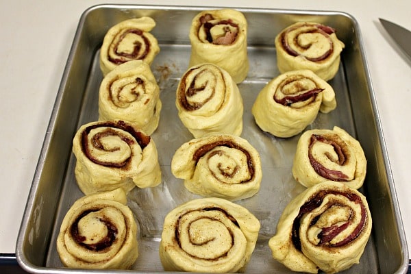 Maple Bacon Cinnamon Rolls with bacon in the middle of each roll - ready to rise in pan