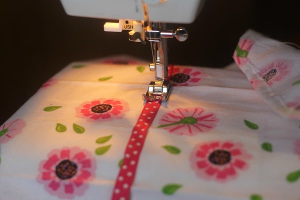 Sewing ribbon on children's dish towel apron