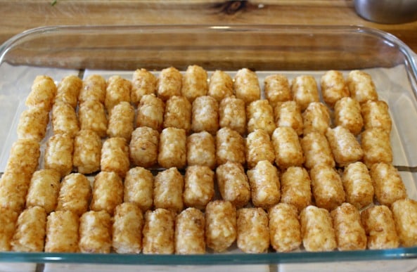 layer tater tots in baking dish to make this Jalapeno Popper Casserole recipe