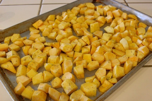Toss Cubed Acorn Squash with Rosemary and Garlic on baking sheet. Then roast acorn squash.