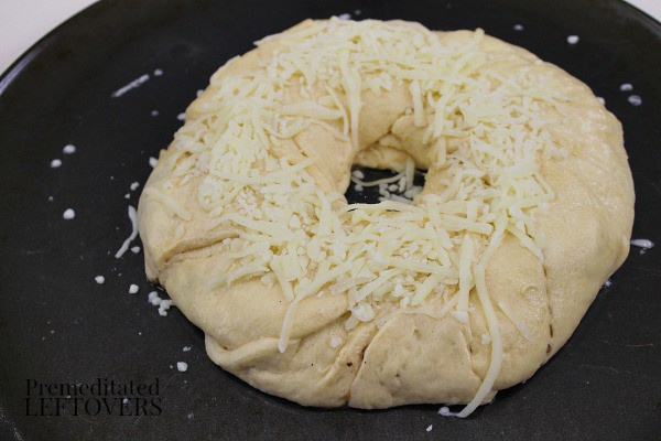 fold dough over, press to seal, and top with cheese