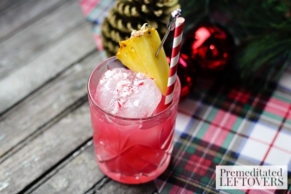 Raise a glass of Christmas cheer! This simple Cranberry, Pineapple, and Peppermint Cocktail recipe is garnished with crushed candy cane and pineapple. 