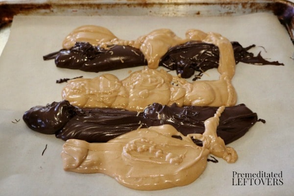 Spoon melted chocolate chips and melted peanut butter chips on tray lined with parchment paper or foil