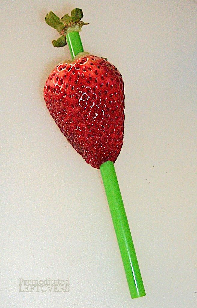 Straw pushed through core of strawberry.