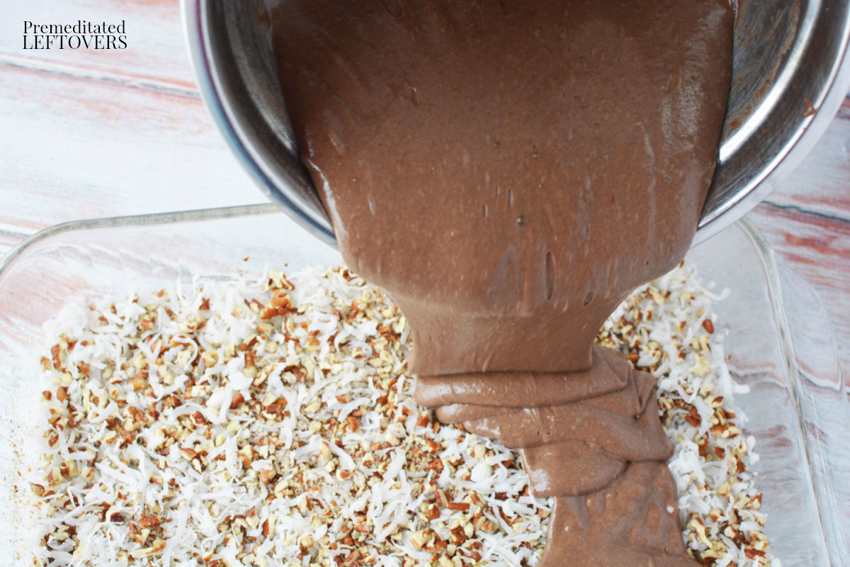 Pour the cake batter over the coconut and pecans.