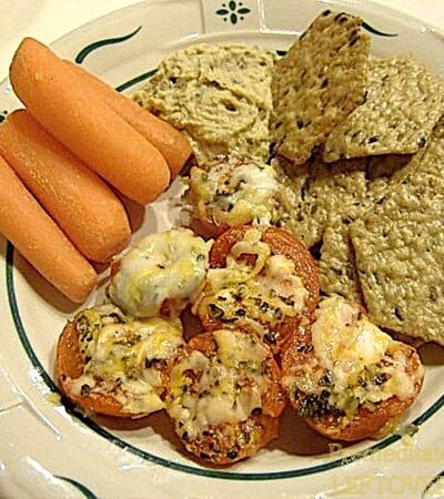 Delicious broiled cherry tomatoes topped with cheese, served with crackers and carrots.