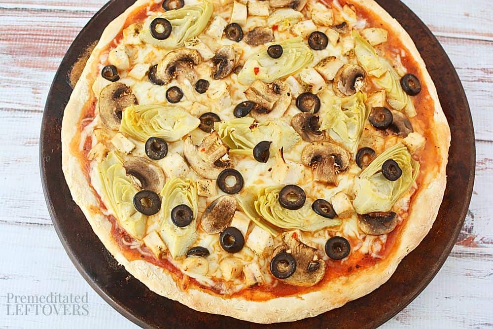 Chicken artichoke pizza after cooking - ready to slice.