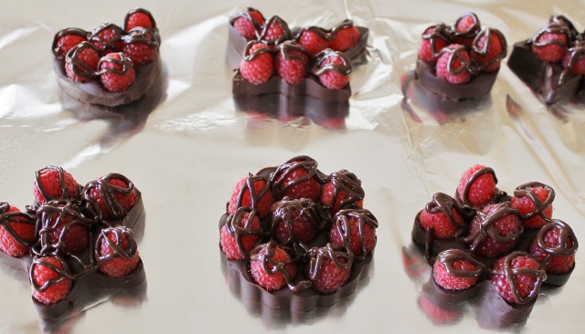 Melted chocolate drizzled over chocolate raspberry bark formed inside of cookie cutters to create fun shapes