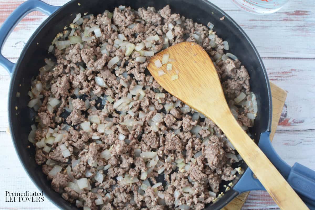 cooking the ground beef, onion, and garlic in a frying pan