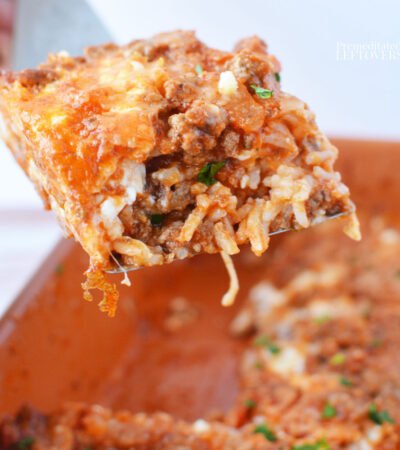 serving a piece of rice lasagna recipe from a baking pan with a spatula