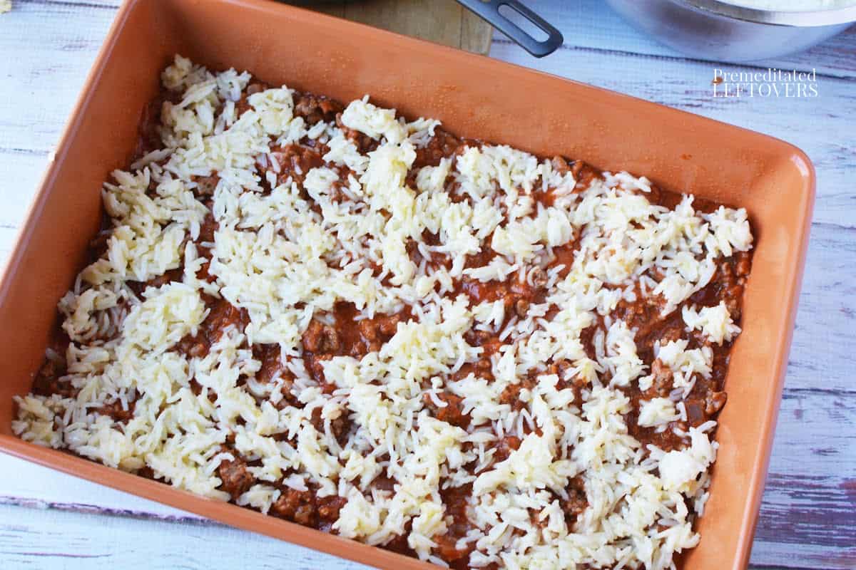 spreading rice over meat sauce