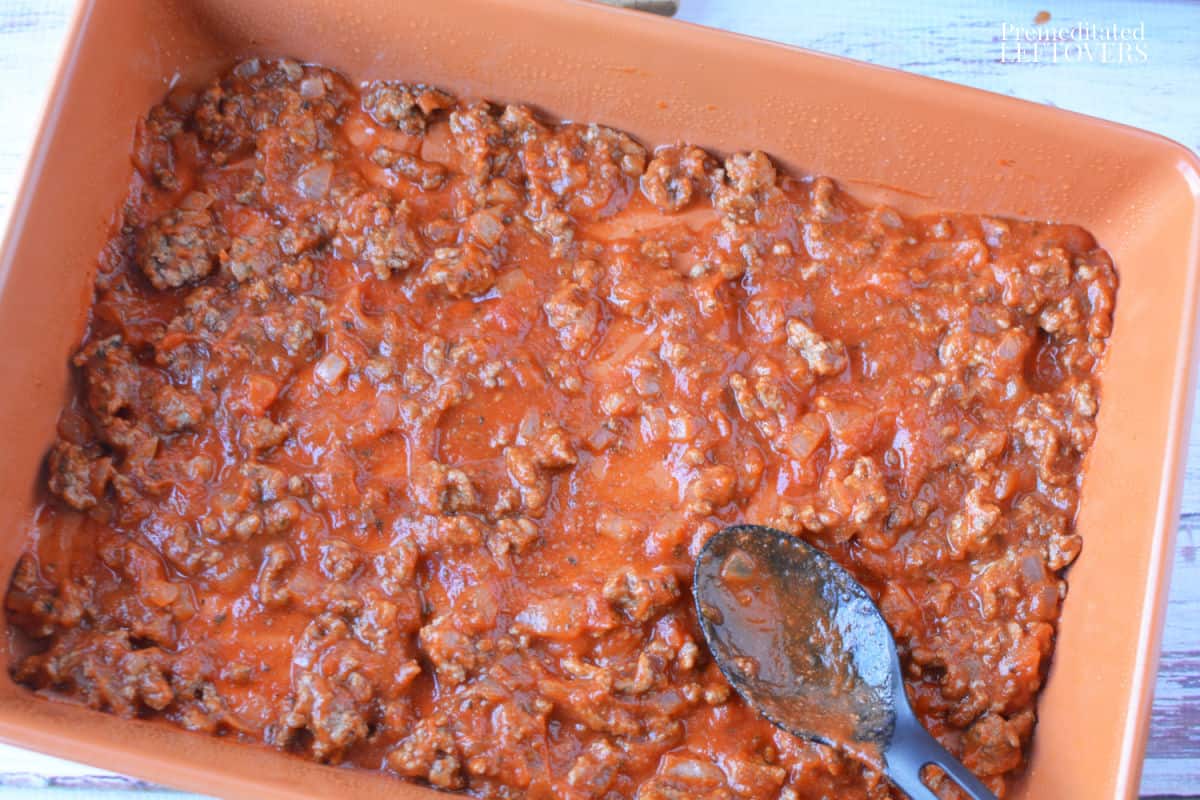 spreading sauce in bottom of baking pan