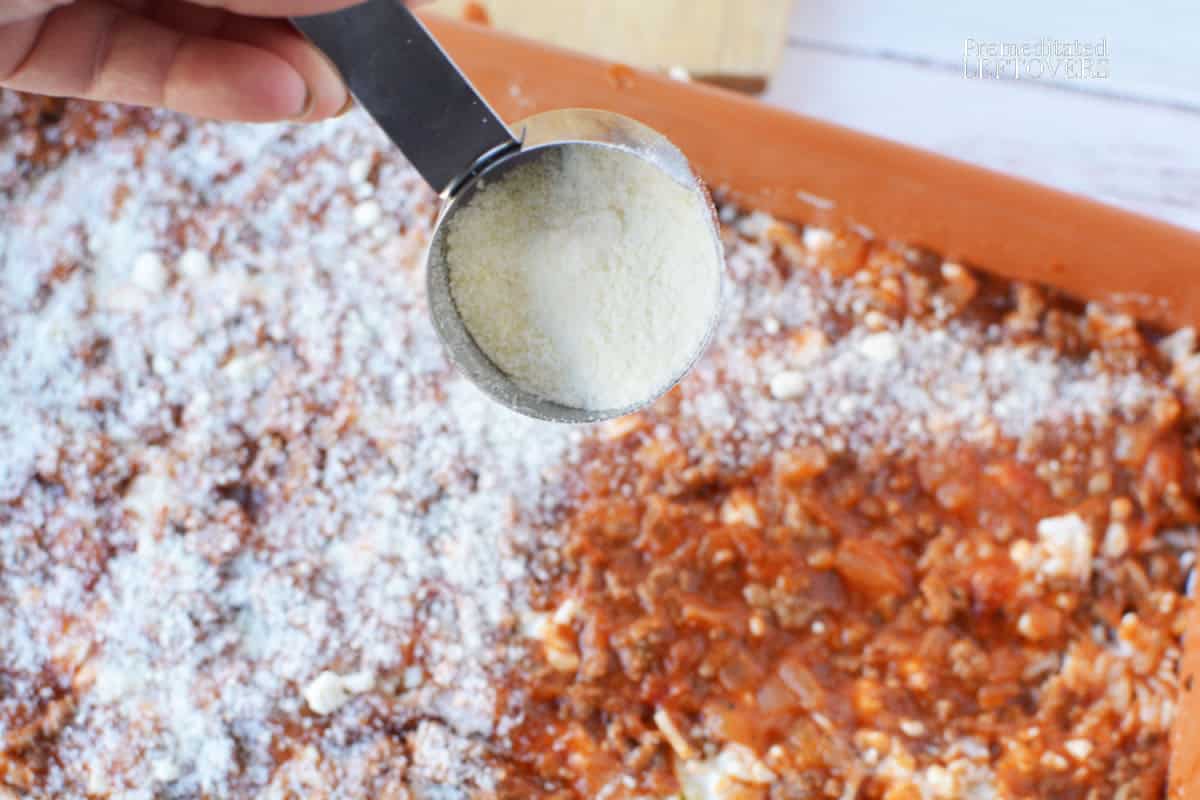 sprinkling grated parmesan over sauce