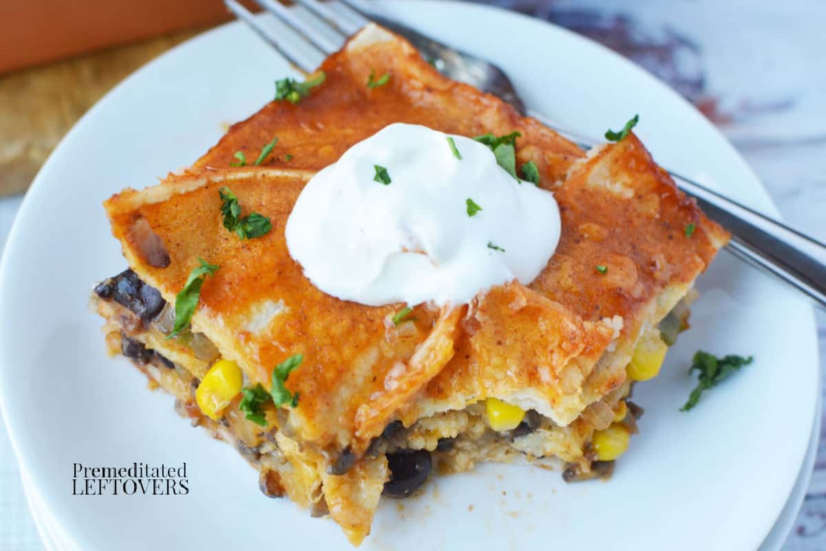 a slice of vegetarian black bean enchilada casserole with a bite missing