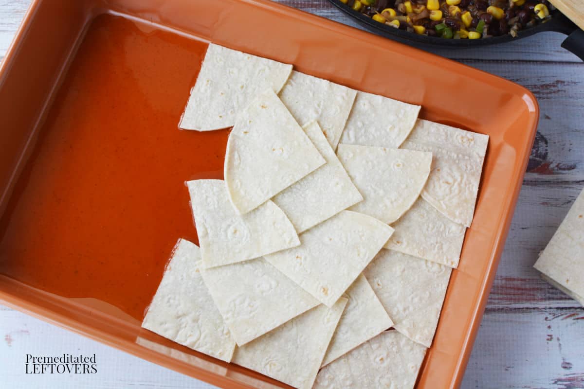 spread enchilada sauce on bottom of baking pan and then place tortilla pieces on top of sauce