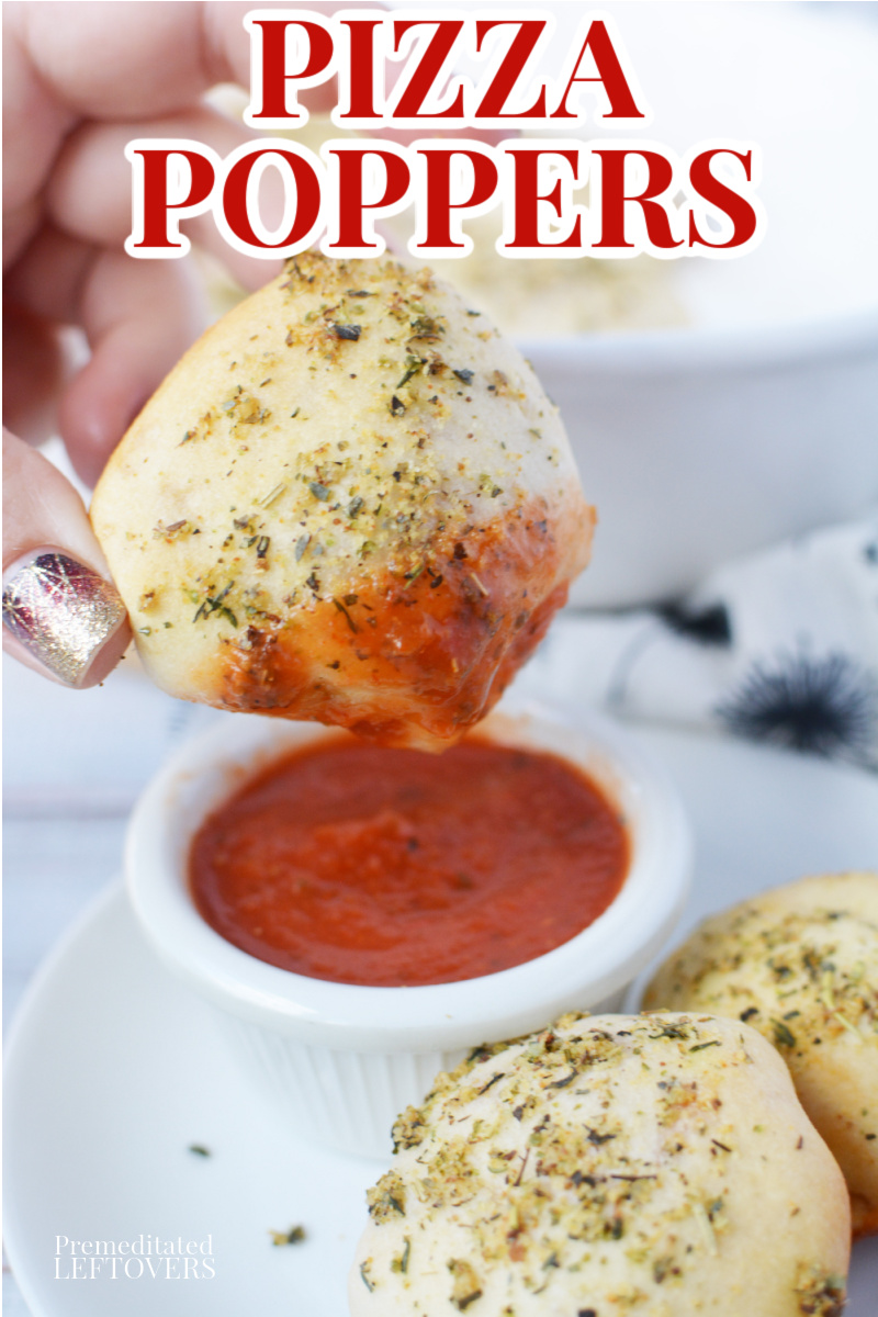 Dipping homemade pizza poppers in pizza sauce.