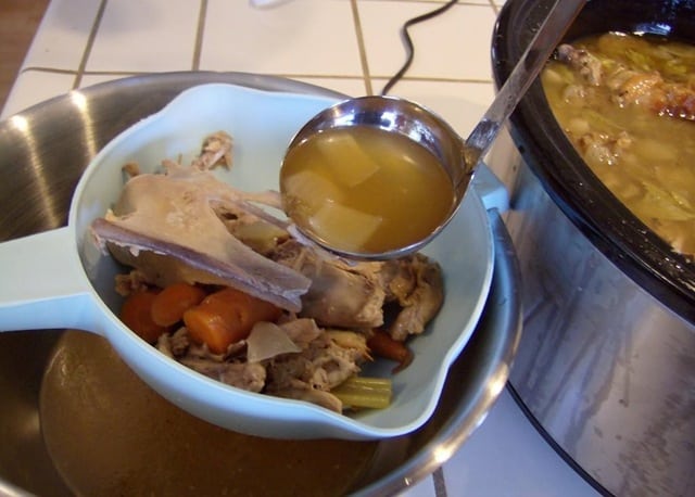 straining the turkey stock to remove the bones and vegetables