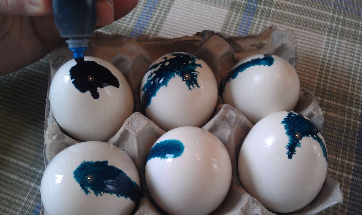 While the boiled eggs are still wet with vinegar, you will start dripping food coloring over the eggs to make tie dye Easter eggs.