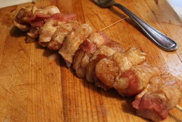 Place bacon wrapped chicken on skewers.
