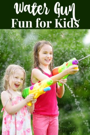 2 kids playing with water guns in the backyard