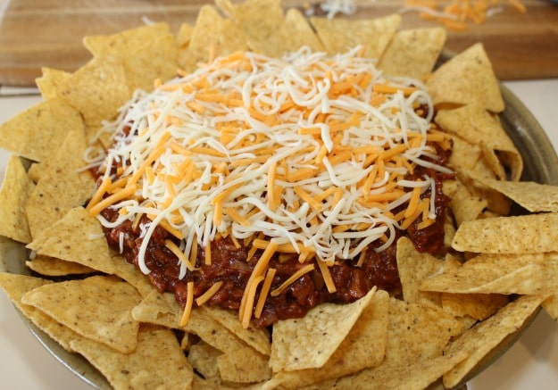 Topping Pulled Pork Nachos with cheese