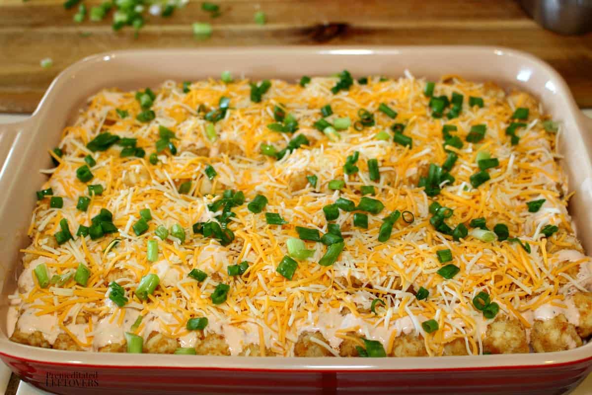 Drizzle the buffalo ranch sauce over the top of the buffalo chicken casserole then sprinkle with cheese and green onions.