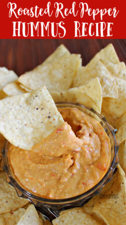 easy homemade roasted red pepper hummus recipe in a dip bowl with chips.
