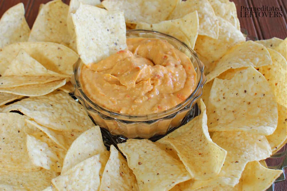homemade roasted red pepper hummus in a dip bowl with chips.
