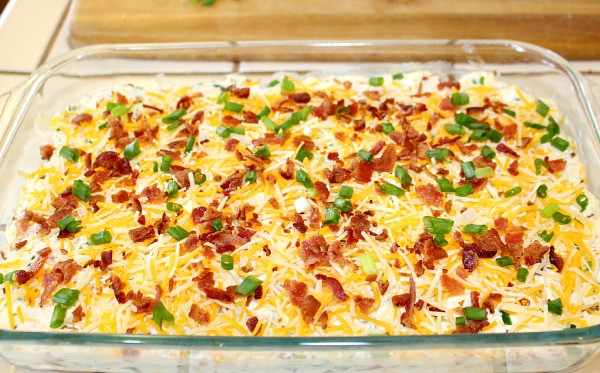 jalapeno popper tater tot casserole recipe topped with cheese, bacon, and green onions.