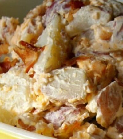 loaded potato salad recipe in bowl topped with bacon and cheese