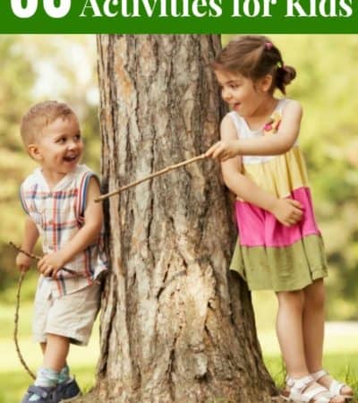 boy and girl playing with sticks by tree -