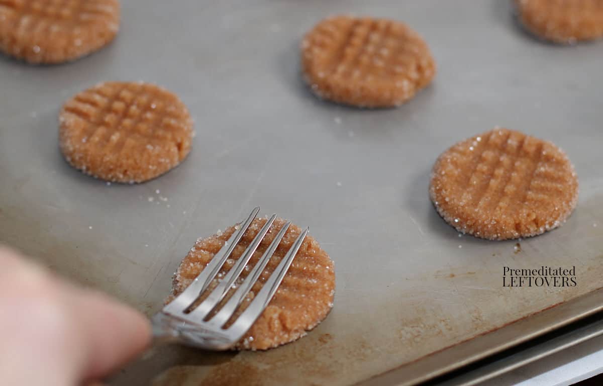 use a fork to flatten the peanut butter cookie dough
