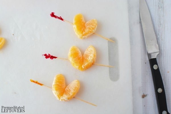 Use toothpicks to hold the orange "hearts" together. The toothpicks look like arrows going through the hearts.