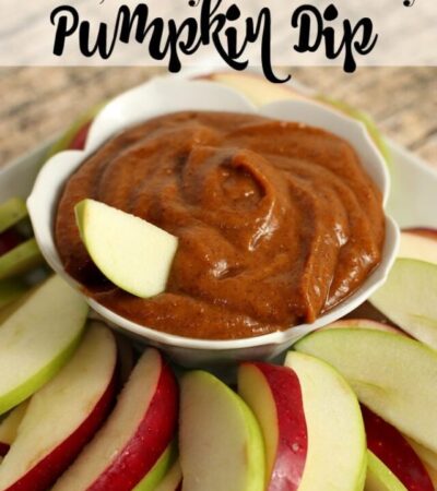 A batch of healthy pumpkin dip recipe in bowl with sliced red and green apples.