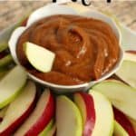 A batch of healthy pumpkin dip recipe in bowl with sliced red and green apples.