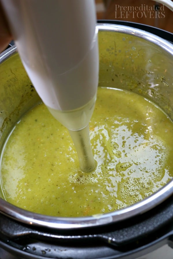 Using an immersion blender to blend the split pea soup after cooking it in an Instant Pot