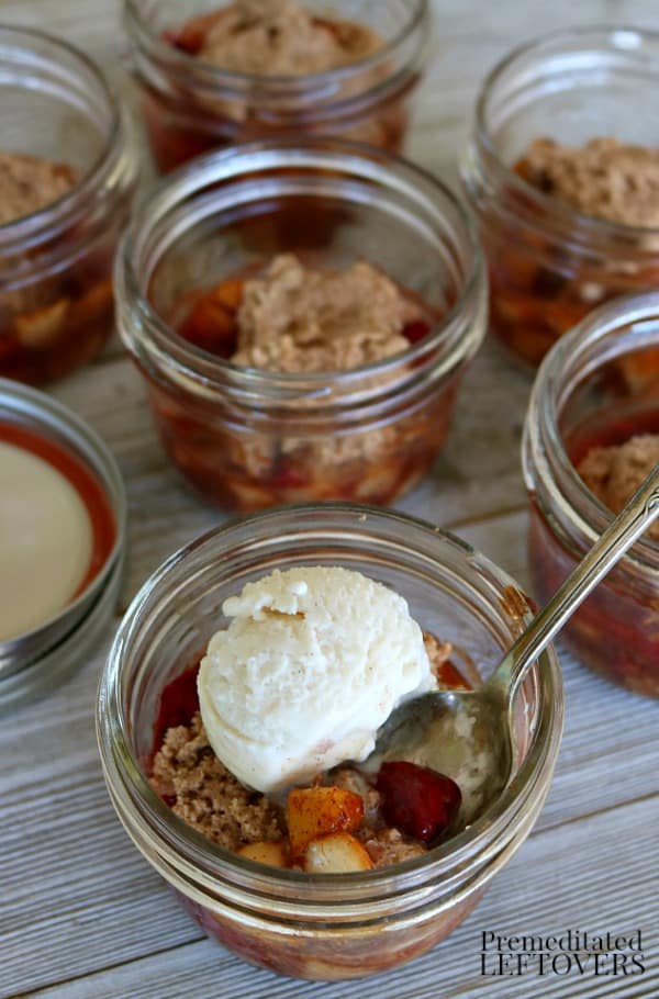 peach and raspberry cobbler recipe in mason jars topped with a scoop of ice-cream