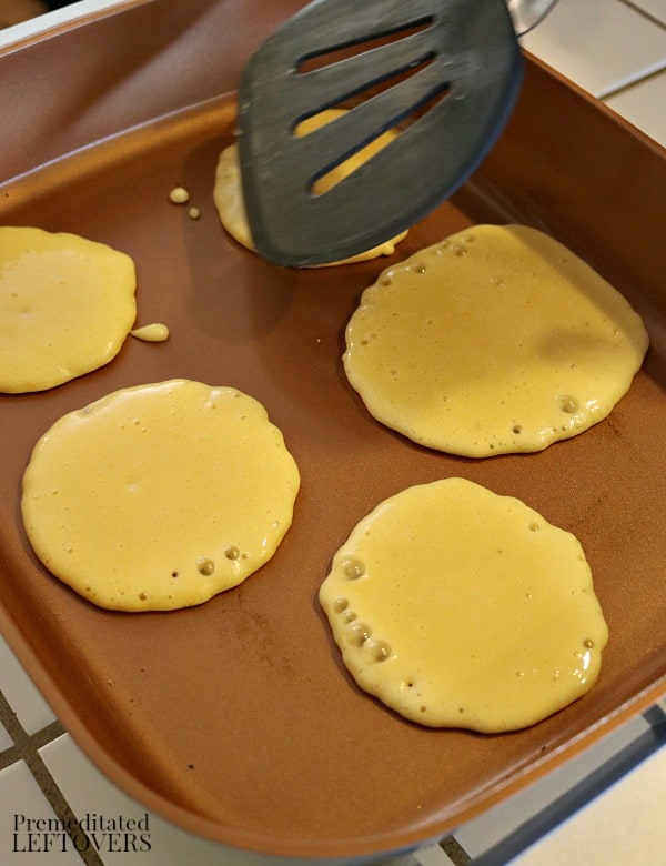 Grain-free pancakes with bubbles on top - a sign they are ready to be flipped.