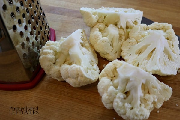 Cut the head of cauliflower into fourths to grate it.