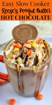 Easy slow cooker Reese's peanut butter hot chocolate recipe topped with a Reese's peanut butter cup and Reese's Pieces.