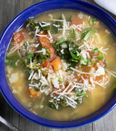 Roasted Tomato Soup Recipe with Basil, cauliflower rice, and kale in a blue bowl.