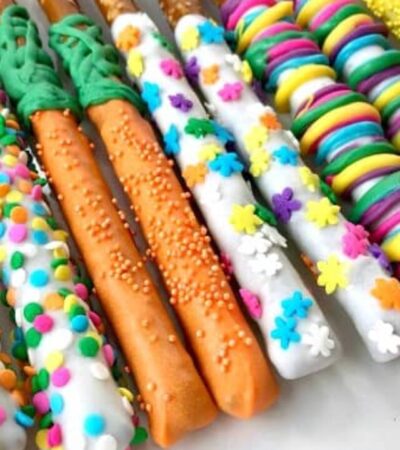 white chocolate covered pretzel rods with easter decorations on plate