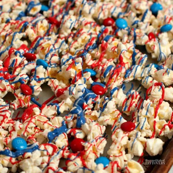 A tray of patriotic candy coated popcorn topped with red and blue M&Ms