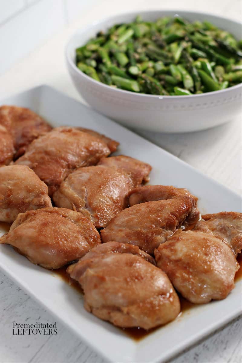 sauteed asparagus and teriyaki chicken in serving dishes for dinner