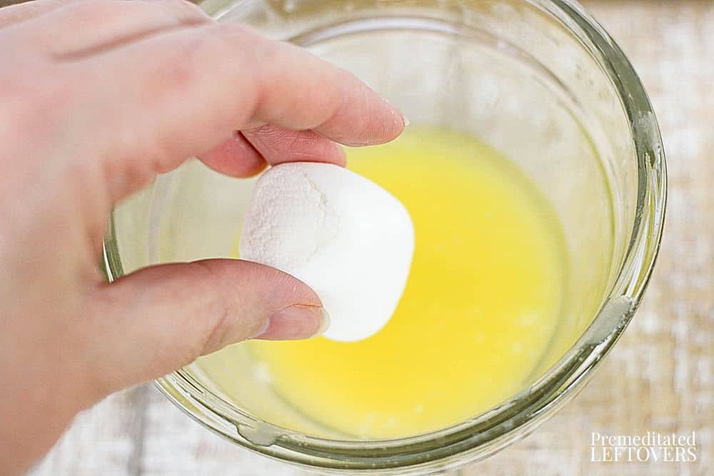 Dipping marshmallow in melted butter for Resurrection Rolls.