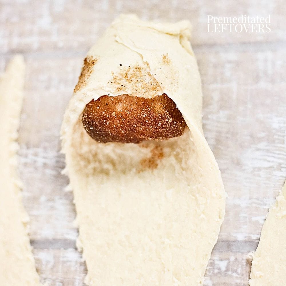 Fold the dough over the marshmallow tightly sealing the edges so the marshmallow does not melt and leak.