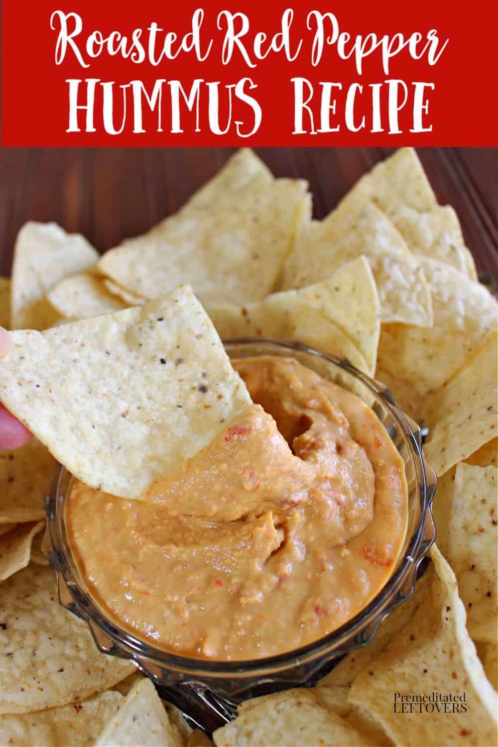 roasted red pepper hummus recipe in a dip bowl surrounded by chips.